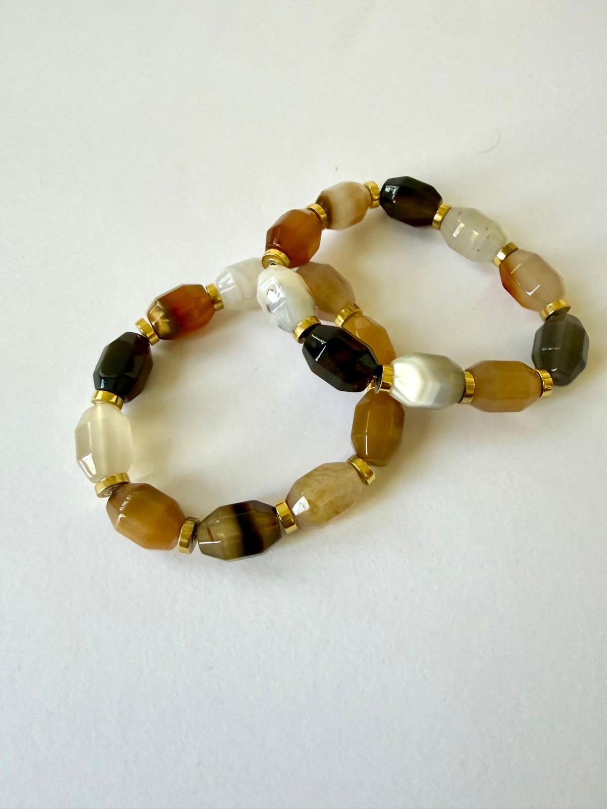 Two faceted jade and hematite stretch bracelets with brown, amber-colored, marbled white, and dark brown beads and gold-tone accents.